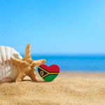 Beautiful beach in the Vanuatu. Flag of Vanuatu in the shape of a heart and shells on a sandy beach.