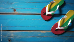 Pair of beach sandals with flag Guinea-Bissau. Slippers for summer sea vacation. Concept travel and vacation in Guinea-Bissau.