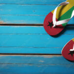 Pair of beach sandals with flag Guinea-Bissau. Slippers for summer sea vacation. Concept travel and vacation in Guinea-Bissau.